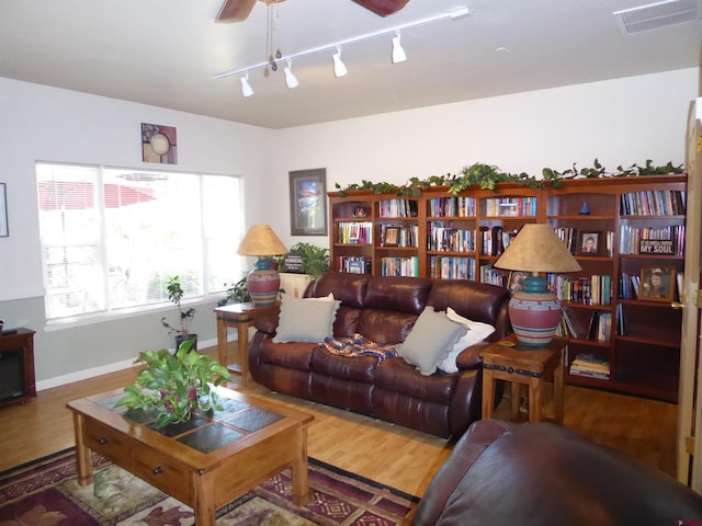 living room featuring rail lighting, visible vents, a ceiling fan, and wood finished floors