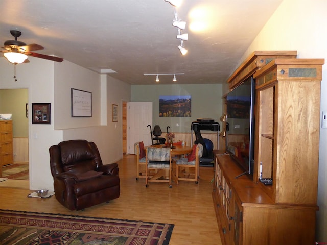 living area featuring light wood finished floors and a ceiling fan