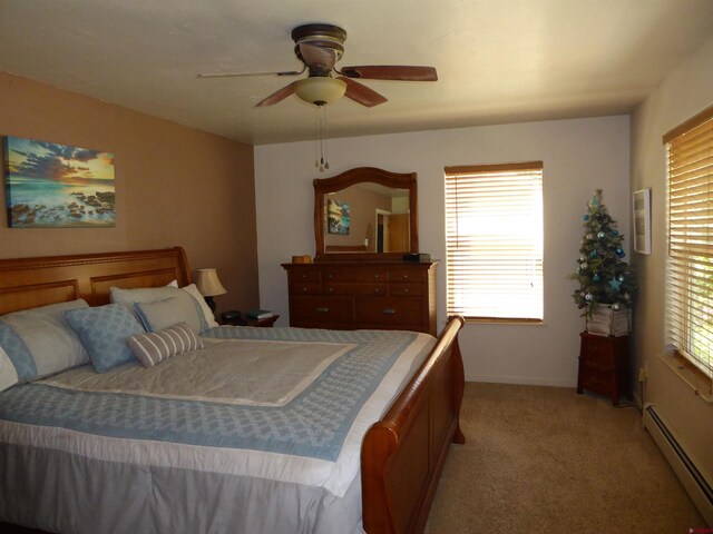 bedroom with ceiling fan, light carpet, baseboards, and a baseboard heating unit