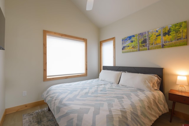 bedroom featuring multiple windows, vaulted ceiling, and wood finished floors