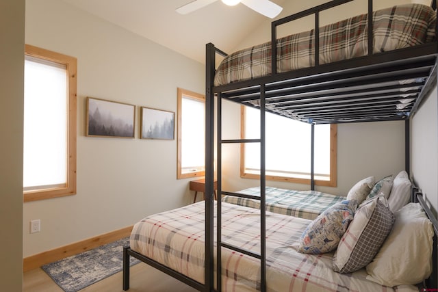 bedroom featuring vaulted ceiling, baseboards, a ceiling fan, and wood finished floors