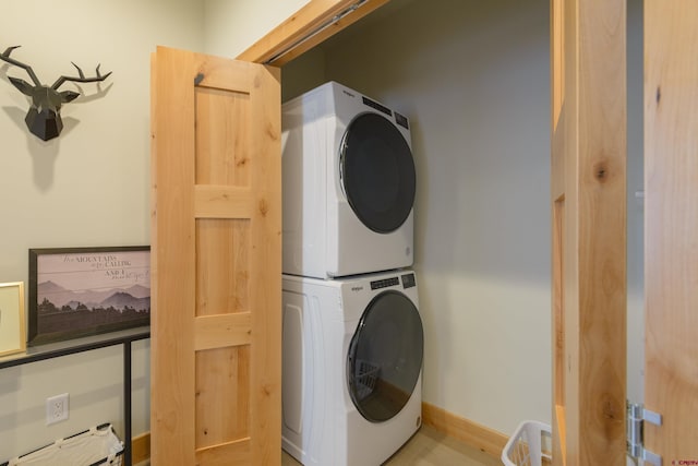 laundry room with laundry area, baseboards, and stacked washer / drying machine