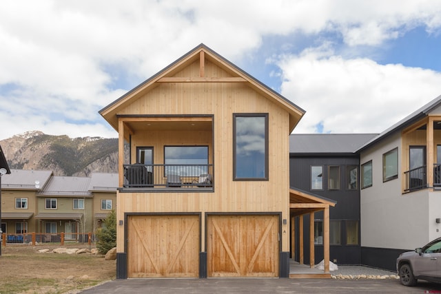 view of front of home with aphalt driveway, an attached garage, and a mountain view