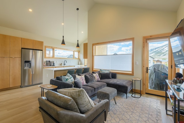 living room with recessed lighting, light wood-style floors, and high vaulted ceiling
