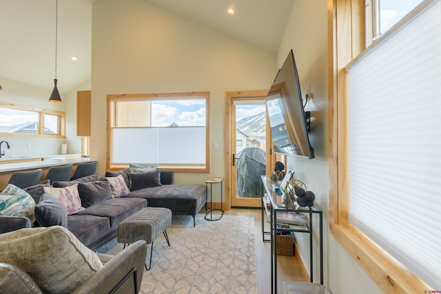 living room with recessed lighting, high vaulted ceiling, a healthy amount of sunlight, and light wood-style floors