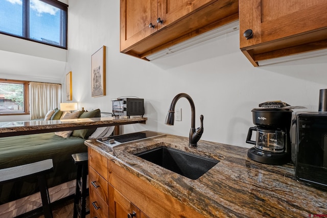 365 S Tamarron Dr Unit 747, Durango, CO 81303 - kitchen featuring brown cabinetry, a healthy amount of sunlight, dark stone countertops, and a sink