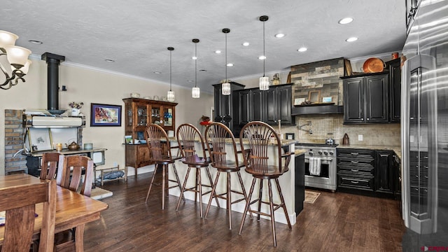 2605 Antler Ct, Crawford, CO 81415 - kitchen with high end stove, dark cabinetry, crown molding, tasteful backsplash, and an island with sink