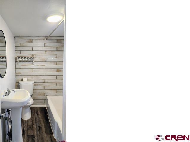 bathroom with toilet and wood finished floors