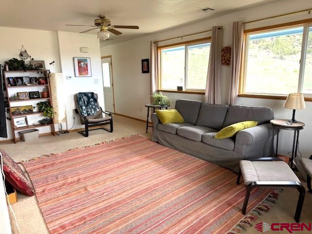 30022 Rd L, Mancos, CO 81328 - living area with a ceiling fan and carpet floors