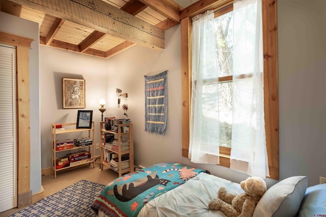 bedroom with wooden ceiling, carpet floors, and beam ceiling