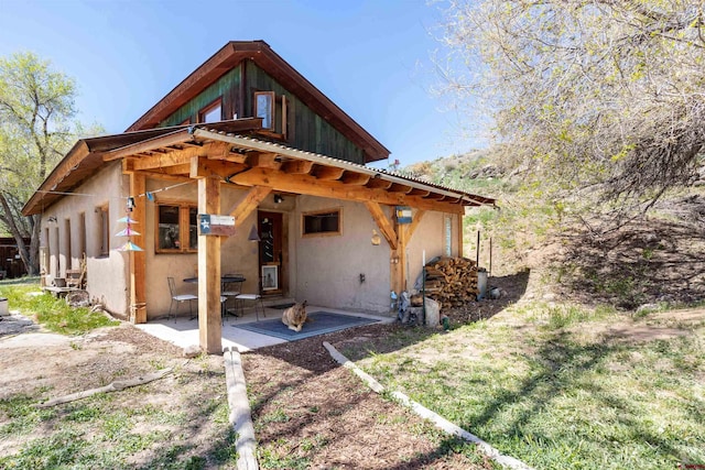 rear view of house featuring a patio and stucco siding