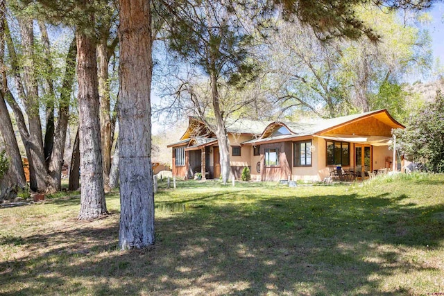 rear view of house featuring a yard