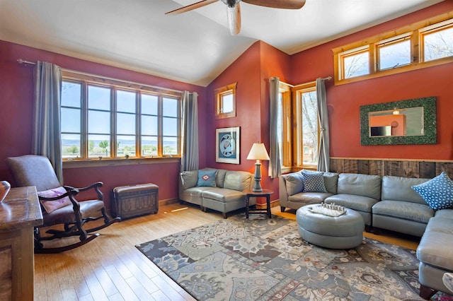 living area featuring vaulted ceiling, wood-type flooring, and a ceiling fan