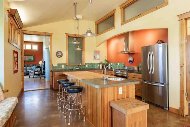 kitchen featuring a sink, concrete flooring, appliances with stainless steel finishes, and wall chimney exhaust hood