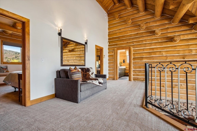 carpeted living area with high vaulted ceiling, beam ceiling, baseboards, wooden ceiling, and rustic walls