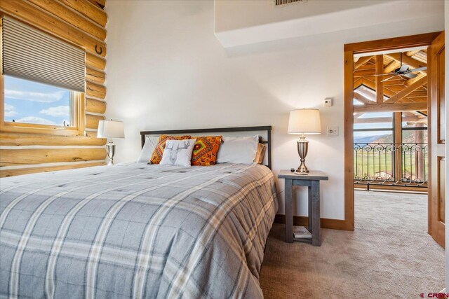 bedroom featuring carpet flooring, baseboards, rustic walls, and visible vents