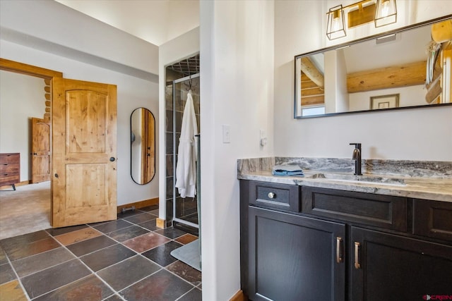 bathroom featuring vanity, a stall shower, and stone finish floor