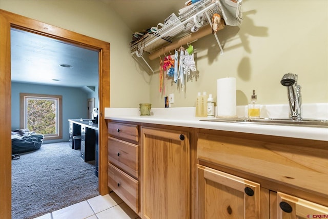 interior space featuring a sink, light carpet, and light tile patterned floors