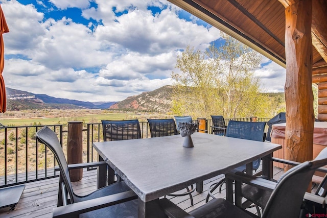 wooden deck with outdoor dining area and a mountain view