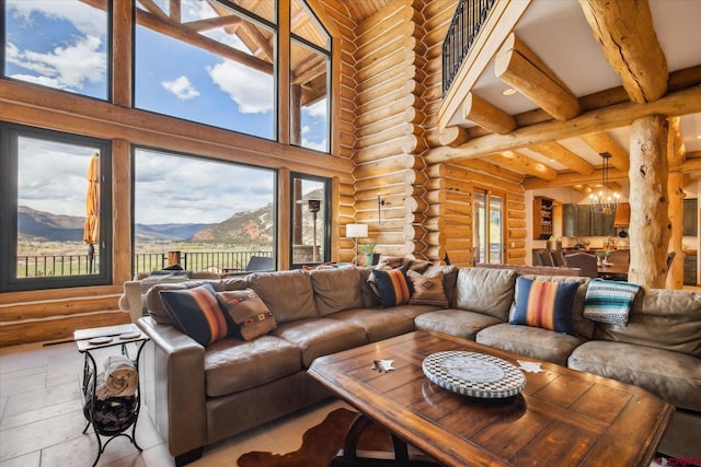living room with a healthy amount of sunlight, rustic walls, a chandelier, and a towering ceiling