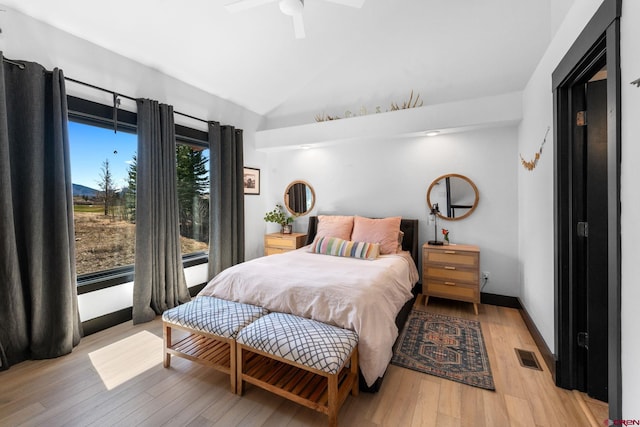 bedroom with vaulted ceiling, light wood finished floors, ceiling fan, and visible vents