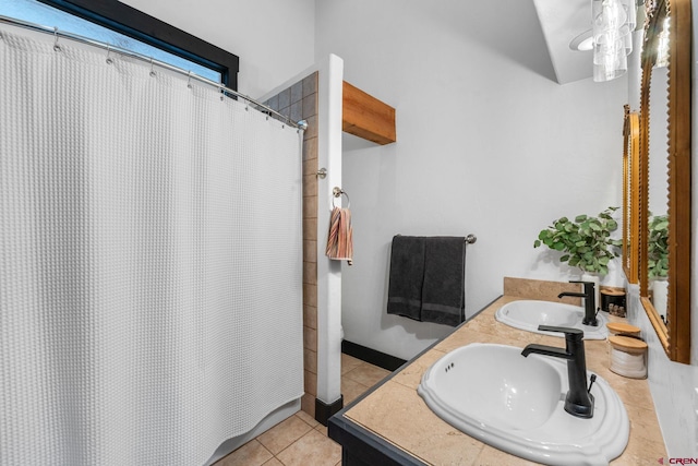 full bath featuring double vanity, curtained shower, tile patterned flooring, and a sink