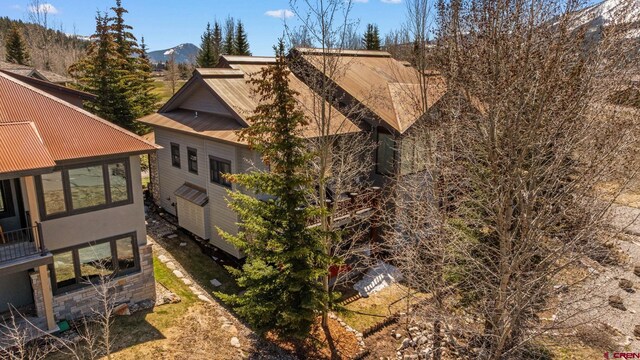 view of side of property featuring metal roof, stucco siding, and a mountain view