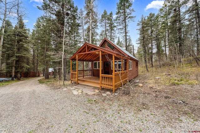 exterior space featuring a forest view and faux log siding
