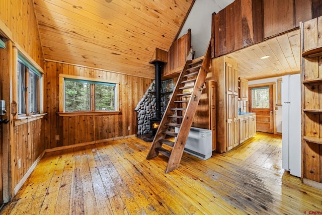 staircase with wood ceiling, wood walls, lofted ceiling, and hardwood / wood-style flooring