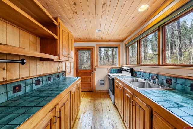 kitchen with tasteful backsplash, tile counters, a sink, and electric stove