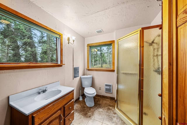 bathroom with vanity, a wealth of natural light, a shower stall, and visible vents