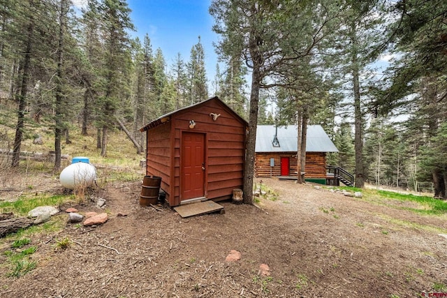 view of shed with a forest view