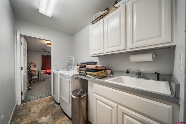 clothes washing area featuring cabinet space, washer and clothes dryer, and stone finish flooring