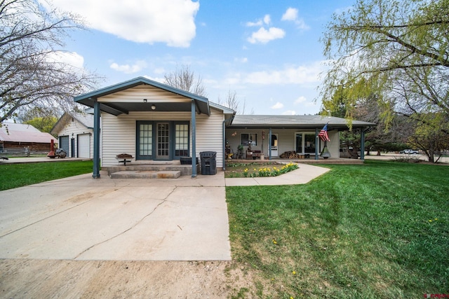 view of front of property with covered porch, a garage, and a front yard