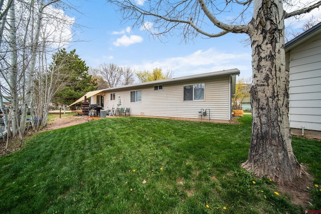 rear view of property with a lawn and a patio