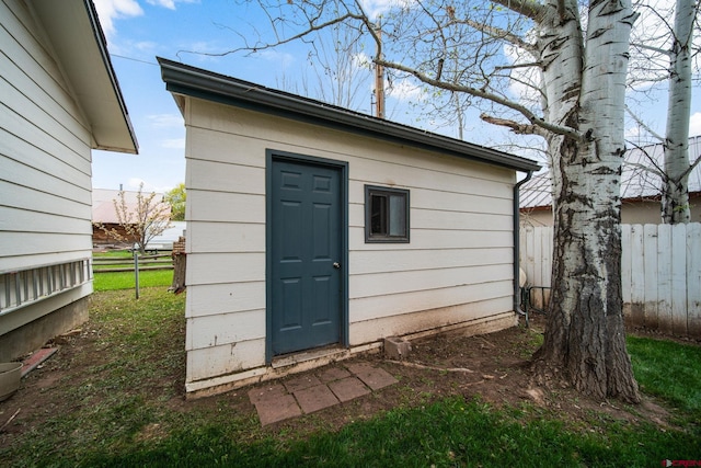 view of outbuilding with fence and an outbuilding