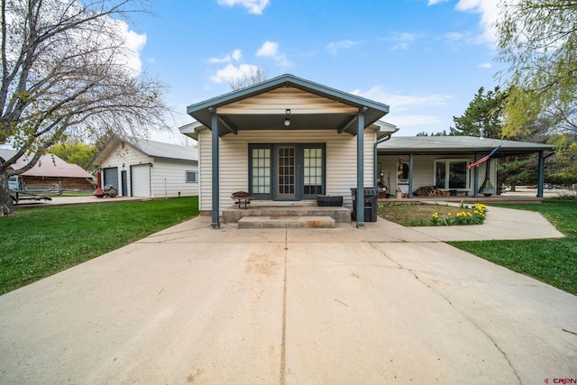 shotgun-style home featuring a porch, a front yard, and a garage