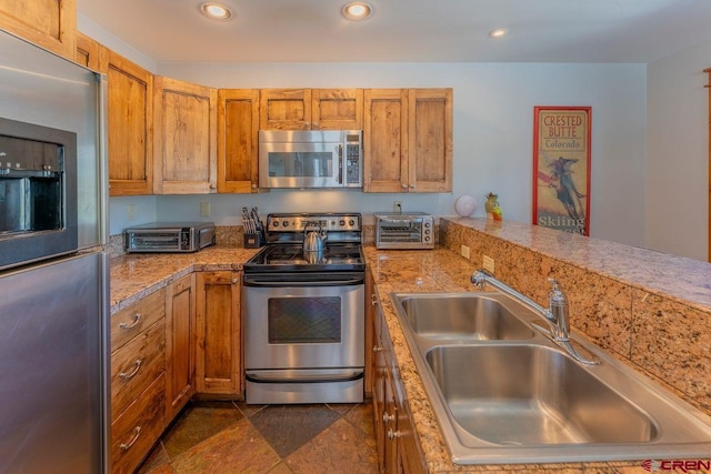 kitchen featuring a sink, recessed lighting, brown cabinets, and appliances with stainless steel finishes