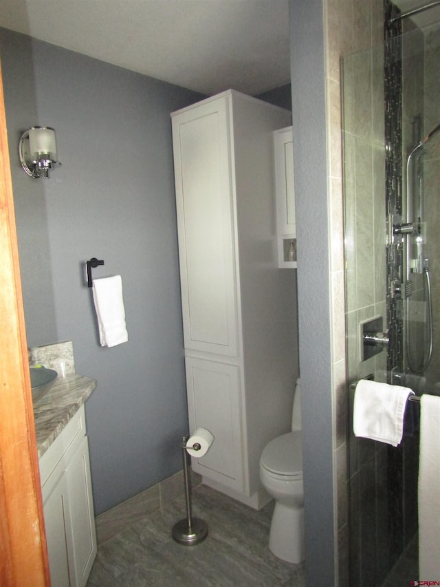 bathroom featuring vanity, toilet, and a shower stall