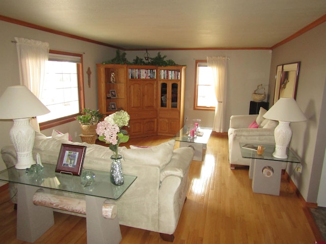 living room featuring plenty of natural light, wood finished floors, baseboards, and ornamental molding