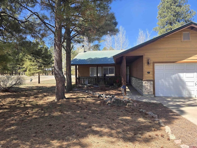 369 Beaver Cir, Pagosa Springs, CO 81147 - view of front facade with metal roof, a garage, a porch, and concrete driveway