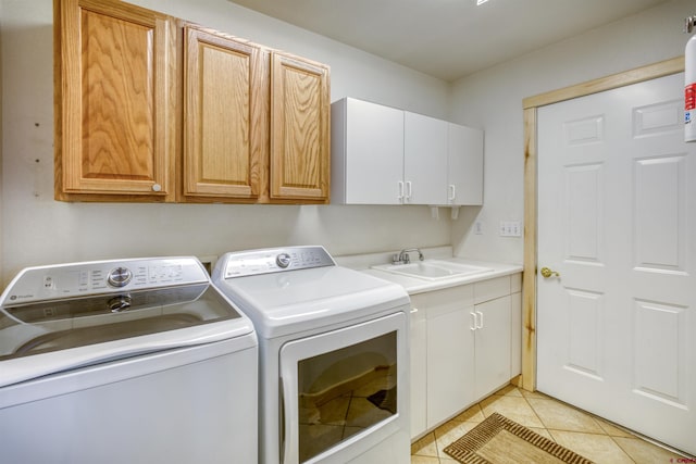 369 Beaver Cir, Pagosa Springs, CO 81147 - clothes washing area with washing machine and clothes dryer, cabinet space, and light tile patterned flooring