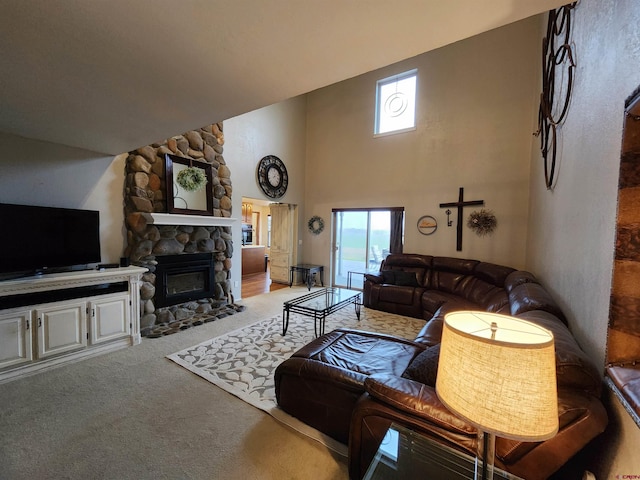 living room with carpet flooring and a stone fireplace