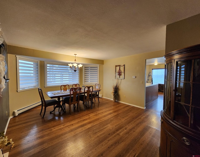 dining space featuring a baseboard heating unit, dark wood-style floors, a notable chandelier, and a textured ceiling