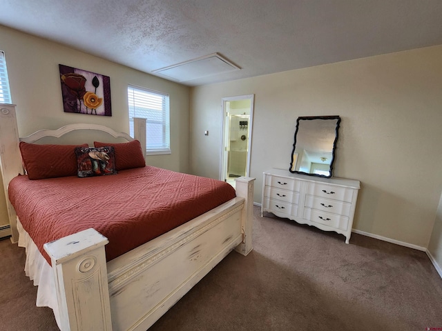 bedroom with dark colored carpet, ensuite bath, and baseboards