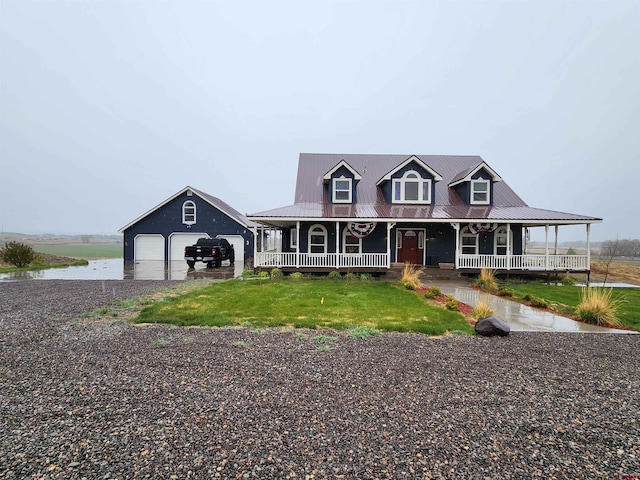 farmhouse featuring covered porch, a garage, metal roof, concrete driveway, and an outdoor structure