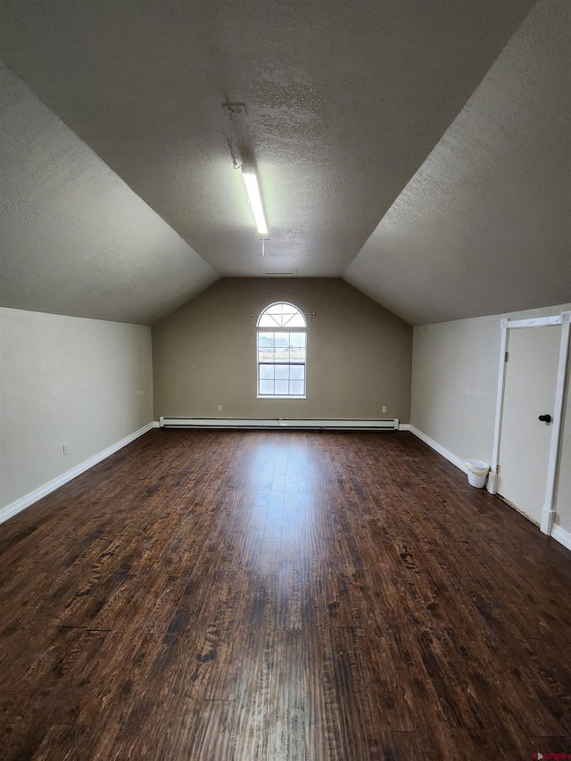 bonus room with a baseboard radiator, a textured ceiling, baseboards, hardwood / wood-style flooring, and vaulted ceiling
