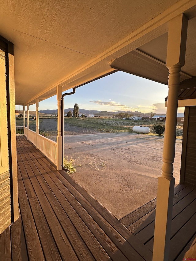 wooden terrace featuring a water and mountain view
