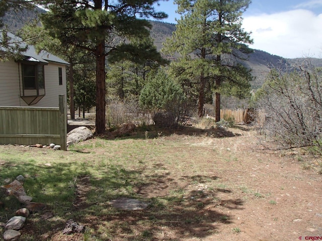 view of yard featuring fence and a mountain view