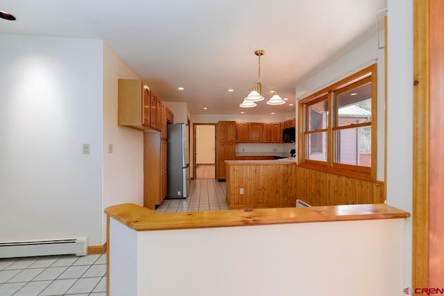 kitchen featuring freestanding refrigerator, light tile patterned floors, a peninsula, and black microwave